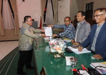 Keterangan Foto: Wali Kota Pematangsiantar, Wesly Silalahi SH MKn (kiri), menyerahkan dokumen Nota Jawaban kepada pimpinan sidang dalam Rapat Paripurna di Gedung Harungguan DPRD Kota Pematangsiantar, Kamis (20/11/2025) malam.