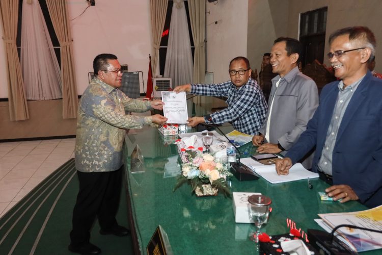 Keterangan Foto: Wali Kota Pematangsiantar, Wesly Silalahi SH MKn (kiri), menyerahkan dokumen Nota Jawaban kepada pimpinan sidang dalam Rapat Paripurna di Gedung Harungguan DPRD Kota Pematangsiantar, Kamis (20/11/2025) malam.